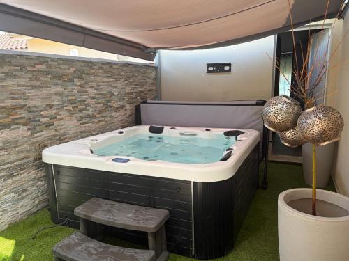 a jacuzzi tub in the middle of a room at Evasion Suite parentale in La Couronne