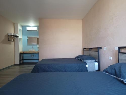 a hotel room with two beds and a kitchen at Suits hotel boutique in Nuevo Casas Grandes
