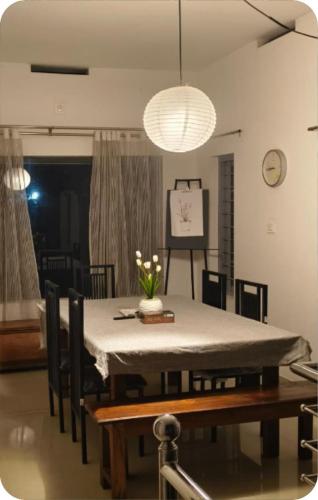a dining room table with a white table cloth on it at The bharani villa in Pulpally