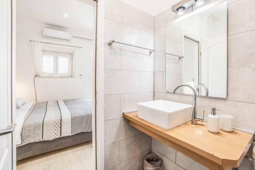 a white bathroom with a sink and a bed at Villa Adriatic Pearl in Dubrovnik