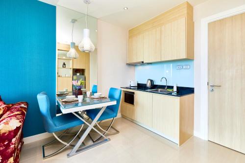 a small kitchen with a table and a blue wall at Grande Carribean apartments Jomtien beach Pool view Sea View in Pattaya South