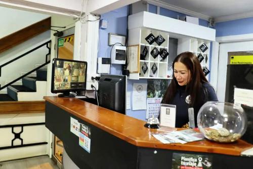 a woman sitting at a counter in a store at HOTEL LOYOLA in Coihaique
