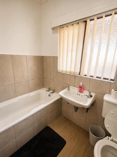 a bathroom with a tub and a sink and a toilet at Die Ou Lady - Dwarskersbos in Velddrif