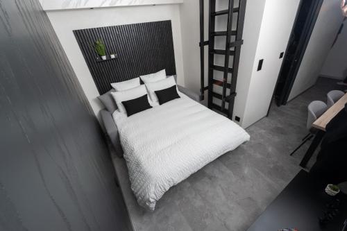 a bedroom with a bed with white sheets and pillows at Studio Le Saphir tout inclus petitdéjeuner in Éloyes