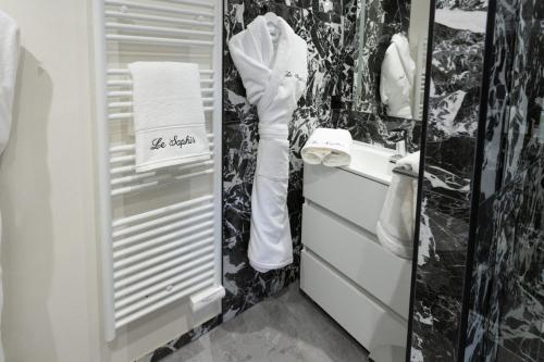 a bathroom with a sink and a white towel at Studio Le Saphir tout inclus petitdéjeuner in Éloyes