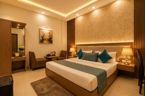 a hotel room with a bed and a chair at The Grand Olive Aero Suites Near Delhi Airport in New Delhi