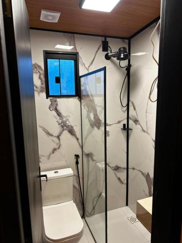 a bathroom with a shower with a toilet and a mirror at Villa Royal in Imperatriz