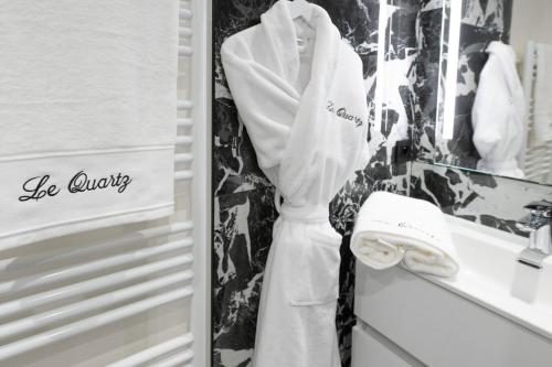 a white robe hanging on a refrigerator door at Studio Le Quartz tout inclus petitdéjeuner in Éloyes