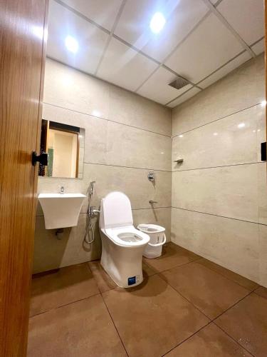 a bathroom with a toilet and a sink at Cozy Rooms & Dormitory in Kozhikode