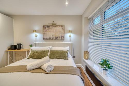 a bedroom with a bed and a window with blinds at Cozy Studio in Eccles - Salford, Manchester in Manchester