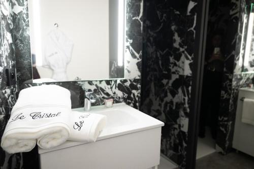 a bathroom with a white sink and a mirror at Studio Le Cristal tout inclus petitdéjeuner in Éloyes
