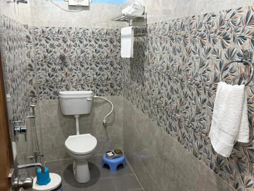 a small bathroom with a toilet and a shower at Prakash Bhawan in Darbhanga
