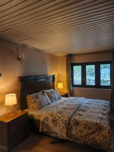 a bedroom with a large bed and two windows at The Jasmine House - Ayubia in Ayubia