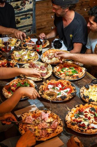 a group of people sitting around a table eating pizza at Goodnight Hostel in Lisbon