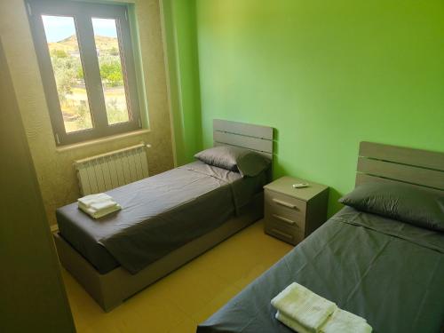 a small bedroom with two beds and a window at La Terrazza in Carrao
