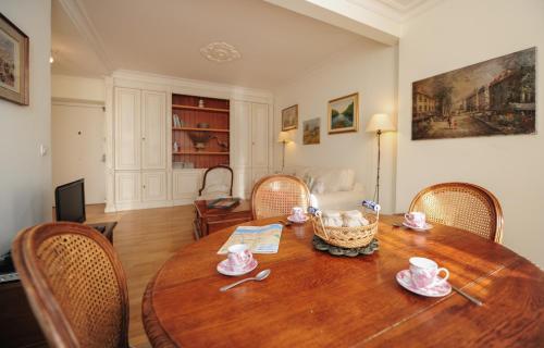 Cette chambre comprend une table et des chaises en bois. dans l'établissement Appartement Clemenceau Centre Nice Five stars Holiday House, à Nice