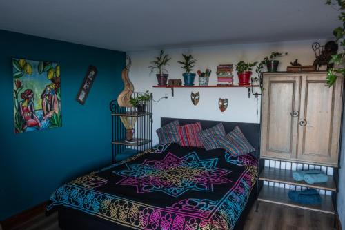 a bedroom with a bed with a colorful bedspread at This Old House in Ponta do Pargo