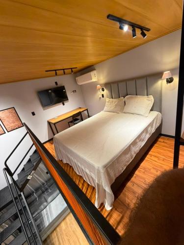 a bedroom with a white bed and a staircase at Villa Royal in Imperatriz