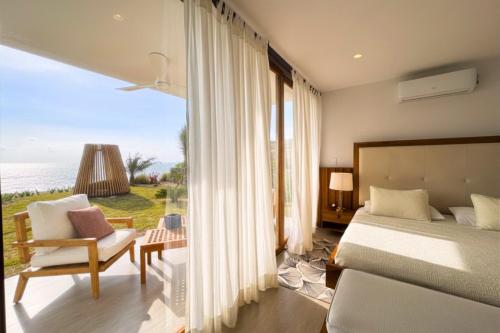 a bedroom with a bed and a view of the ocean at Jama Campay Hotel by Otium in Los Camarones