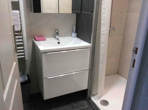 a white bathroom with a sink and a shower at Appartement de vacances au 1er étage 45m2 in Antibes