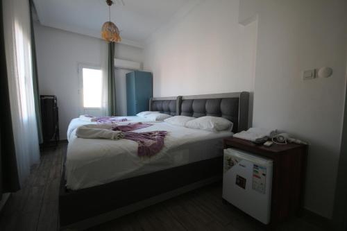 a bedroom with a large bed with white sheets at Okan Ali Gürsoy Otel in Ayvalık