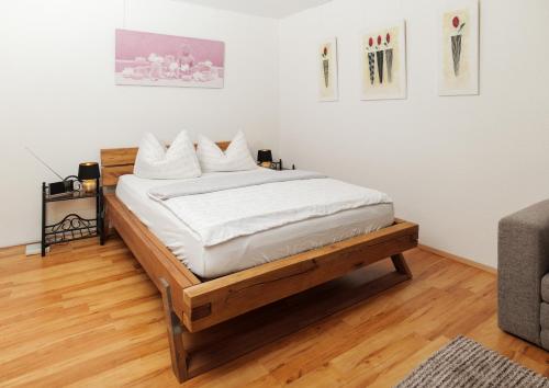a bedroom with a bed with white sheets at Pension Temizdemir in Lahr