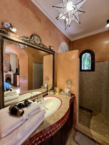 a bathroom with a sink and a large mirror at Palais El Arsat & Spa in Marrakesh