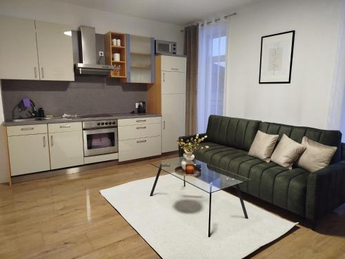 a living room with a green couch and a kitchen at Apartmán VERDE in Suchá Hora