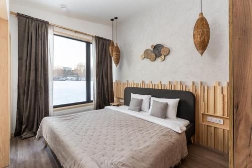 a bedroom with a large bed with a large window at Характер парк in Hatne