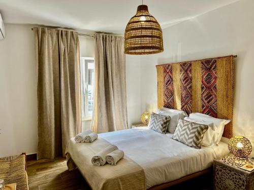 a bedroom with a bed with towels on it at Ocean House Alentejo in Porto Covo