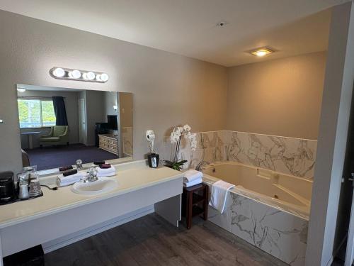 a bathroom with a tub and a sink and a mirror at Bayview Inn in Crescent City