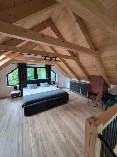 ein Schlafzimmer mit einem großen Bett im Dachgeschoss in der Unterkunft Bez Planu in Zambski Stare