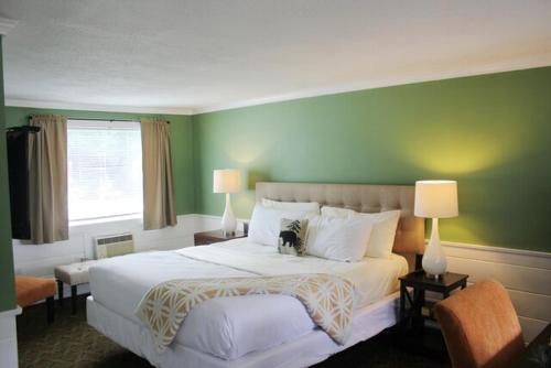 a bedroom with a large bed with a green wall at Scenic Vista Inn in North Conway