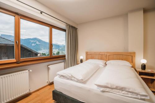 a bedroom with a bed and a large window at La Cort My Dollhouse - Adults Only in Ortisei