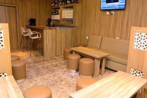 a restaurant with a bar with a table and stools at Bgl suites in Barakin Akawo