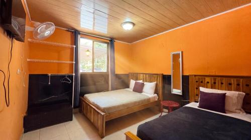 a bedroom with two beds and a window at Roxys Inn in Boca Chica