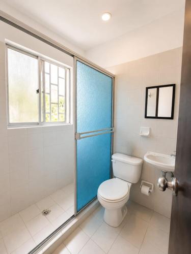 a bathroom with a toilet and a window and a sink at Renta Mar in Barranquilla