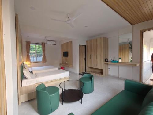 a living room with a couch and a table at Sukhawan Hotel in Kalamb