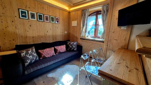 a living room with a couch and a table at Bilocale Ristrutturato in Madesimo