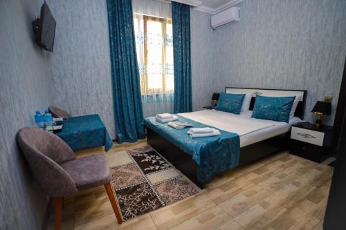a small bedroom with a bed and a chair at Sheki Villa boutique in Sheki