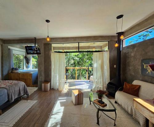 a living room with a bed and a couch at Studio Mata dos Curiós in Petrópolis