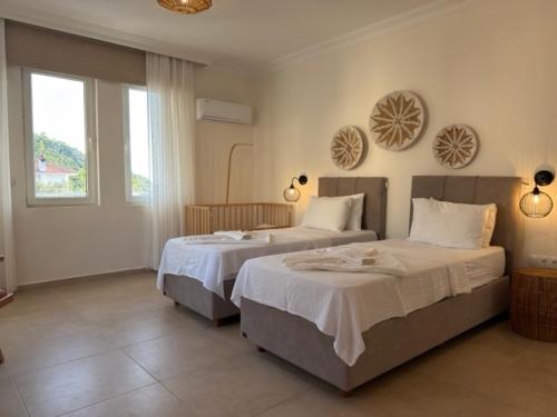 a bedroom with two beds and a window at Villa Zalin in Ovacik