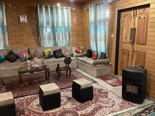 a living room with a couch and a table at Visiting Villa in Srinagar