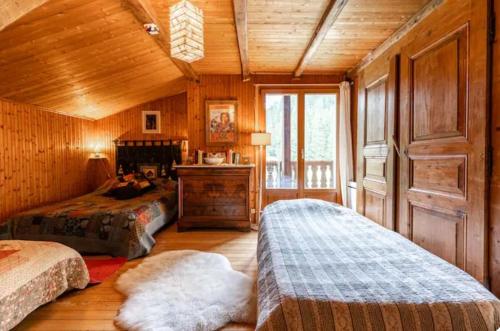 a bedroom with two beds and a wooden ceiling at chambre pour 2 à 4 personnes ,balcon in Mont-Saxonnex