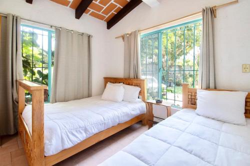 a bedroom with two beds and a window at Geodesic sanctuary with a heated pool in Chiconcuac