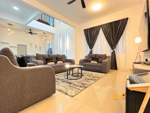 a living room with two couches and a table at Desaru Arcadia Double Storey House 11-16 Pax 5 Mins to Desaru Beach in Bandar Penawar