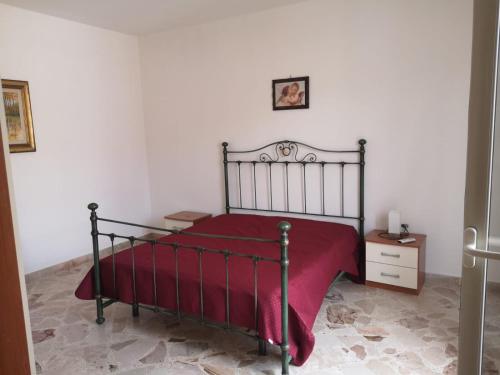 a bedroom with a bed with a red blanket at Terrasini 218 in Terrasini