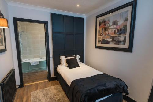 a bedroom with a bed with a black headboard at The Kirkhouse Inn in Strathblane