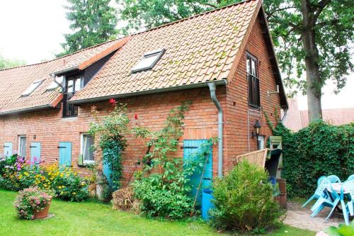 a red brick house with a blue door at Dat Uhlenhus in Bohlsen