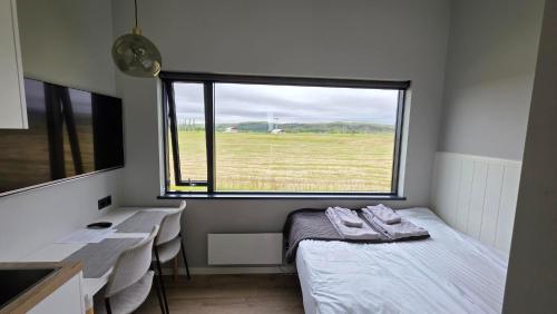 a room with a bed and a desk and a window at Landbrot Guesthouse in Kirkjubæjarklaustur